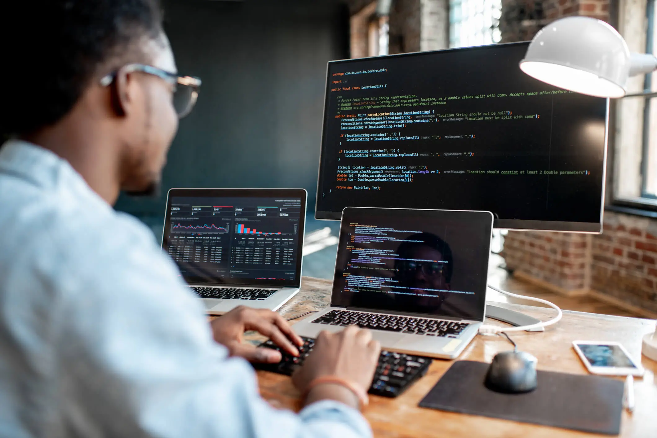 man working with multiple displays on code
